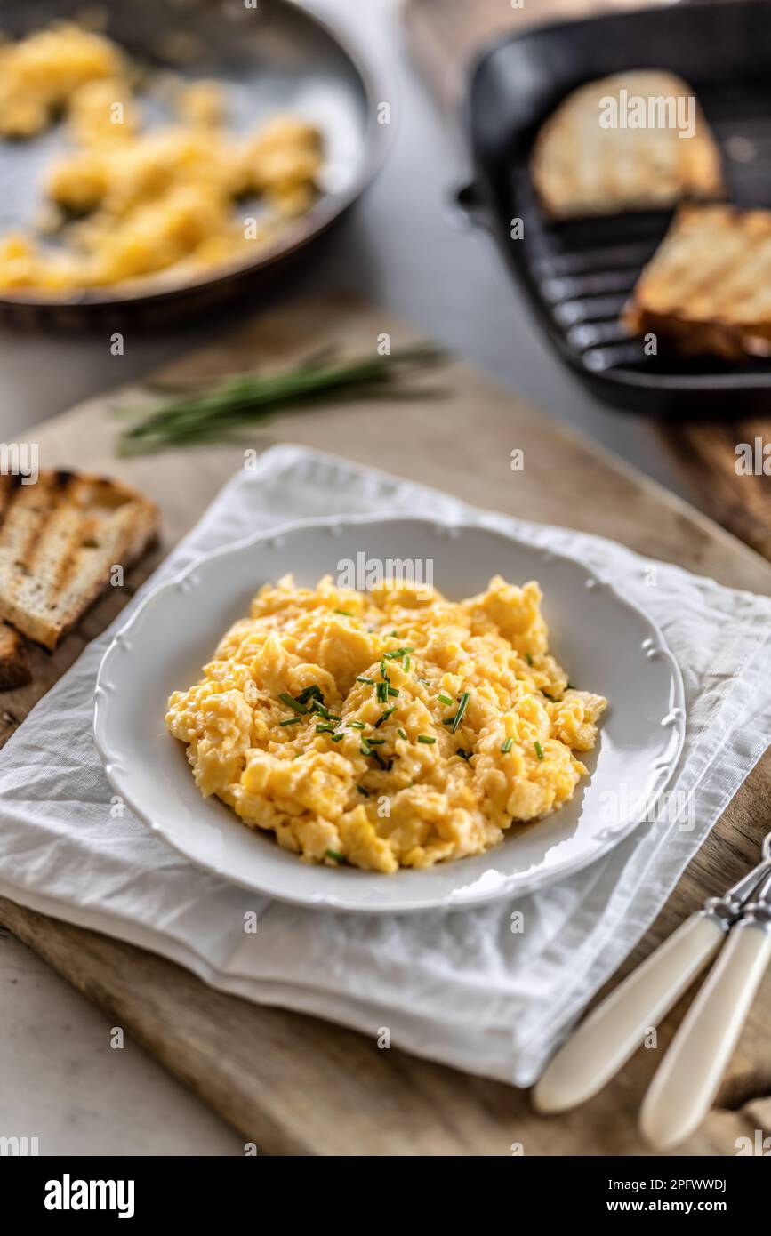 Silky-smooth scrambled eggs made to perfection and served in a plate for breakfast. Stock Photo
