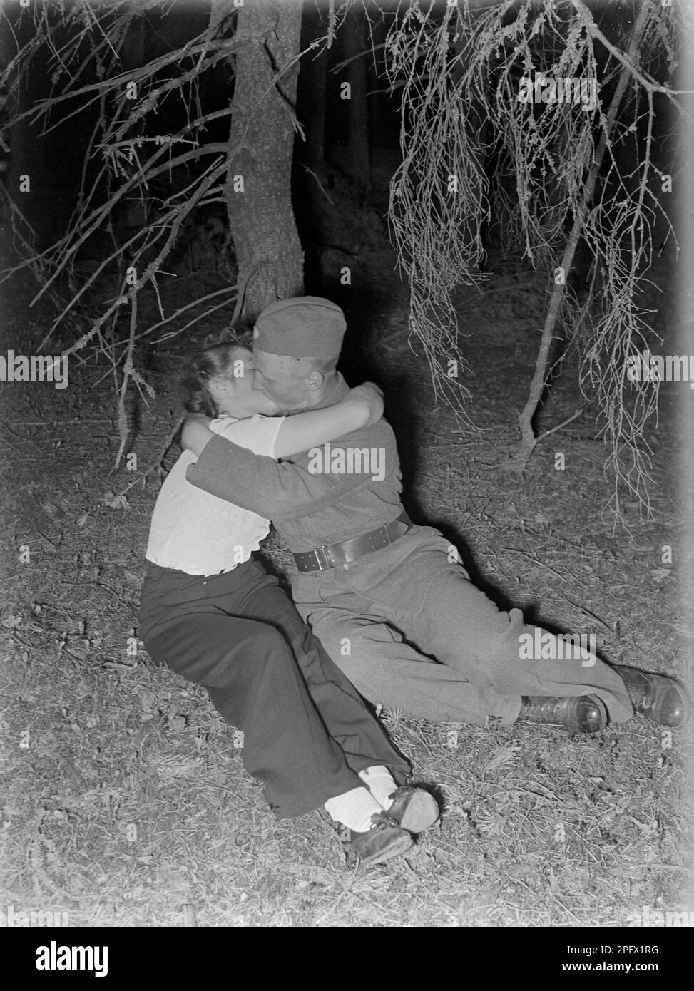 Kissing in the 1940s. A young woman with a soldier in uniform seen kissing and hugging.     Sweden 1941 Kristoffersson Ref 188-2 Stock Photo