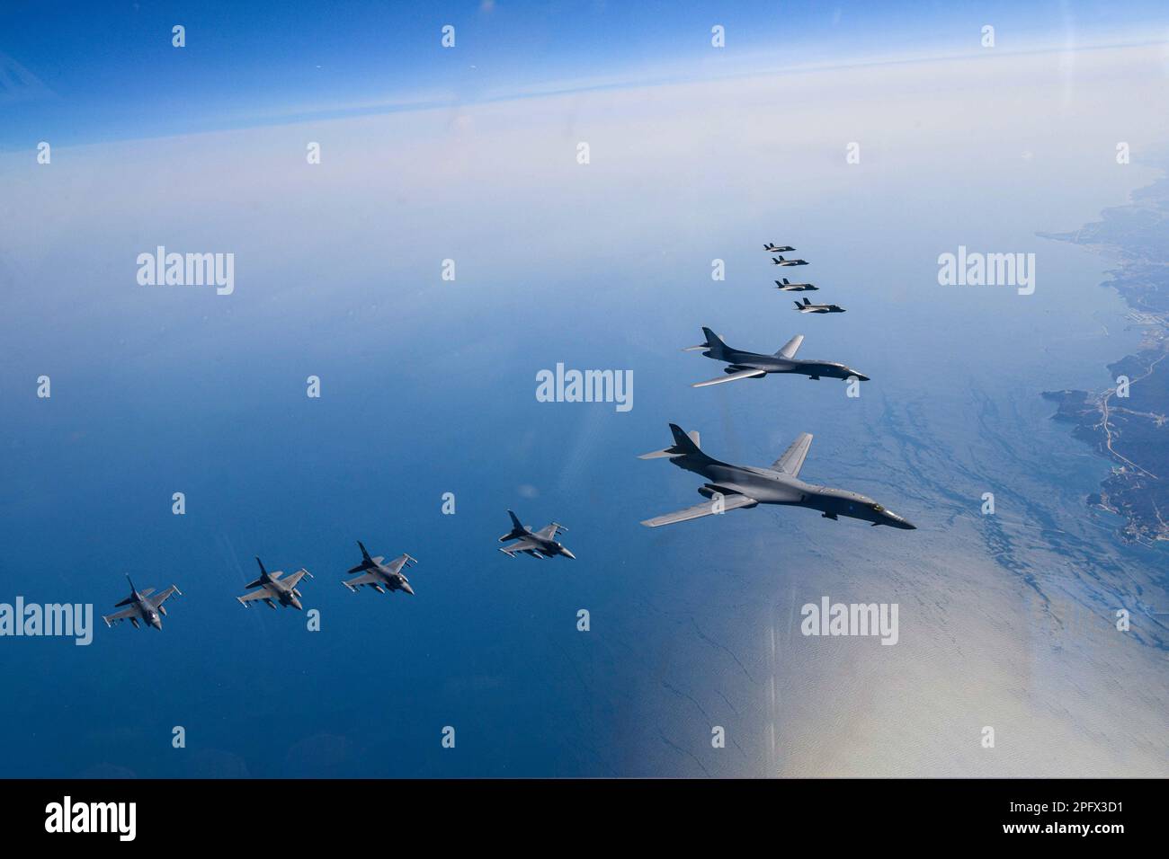 March 19, 2023, OSAN, GYEONGGI, SOUTH KOREA: March 19, 2023-West Sea, South Korea-In this photo provided by South Korea Defense Ministry, U.S. Air Force B-1B bombers, top center, fly in formation with South Korea's Air Force F-35A fighter jets and U.S. Air Force F-16 fighter jets, top right, over the South Korea Peninsula during a joint air drill in South Korea, Sunday, March 19, 2023. North Korea launched a short-range ballistic missile toward the sea on Sunday, its neighbors said, ramping up testing activities in response to U.S.-South Korean military drills that it views as an invasion rehe Stock Photo