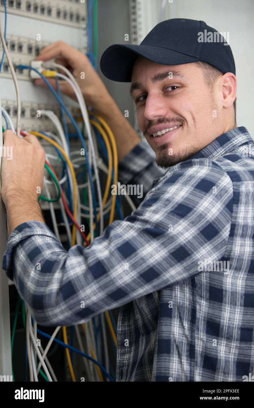 male technician connecting cables to server Stock Photo