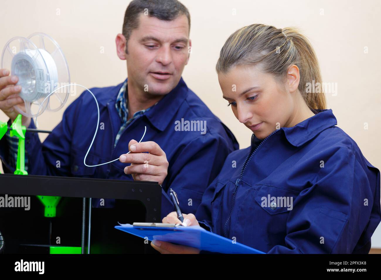 male and female technicians working with 3d printer Stock Photo