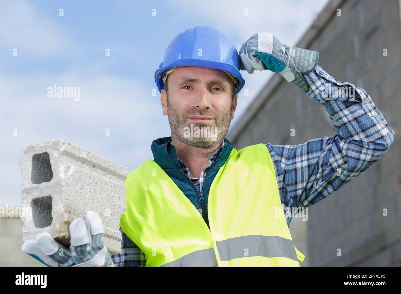 male builder holding a brick at construction site Stock Photo - Alamy