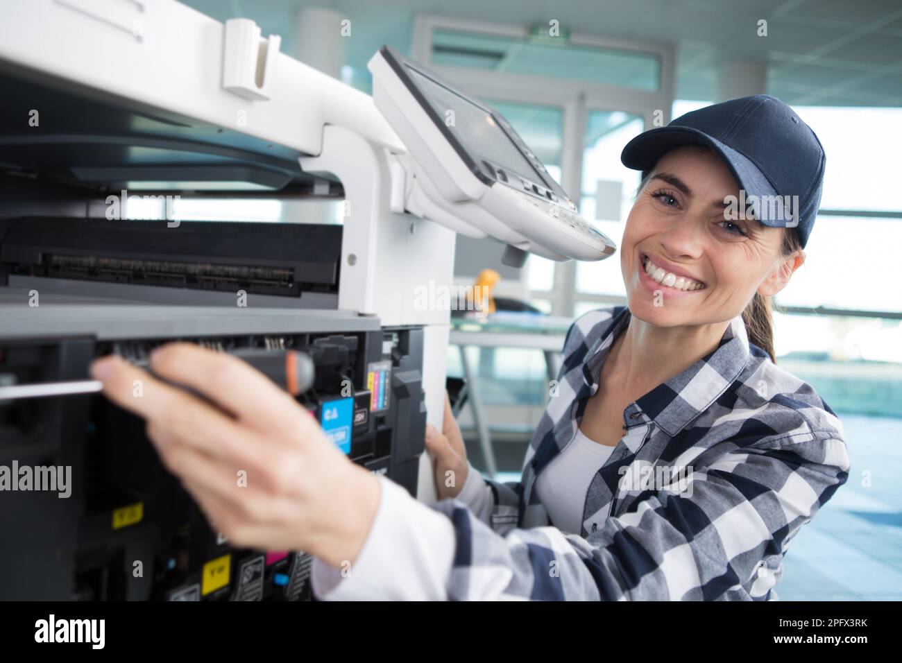 a woman fixing a printer Stock Photo