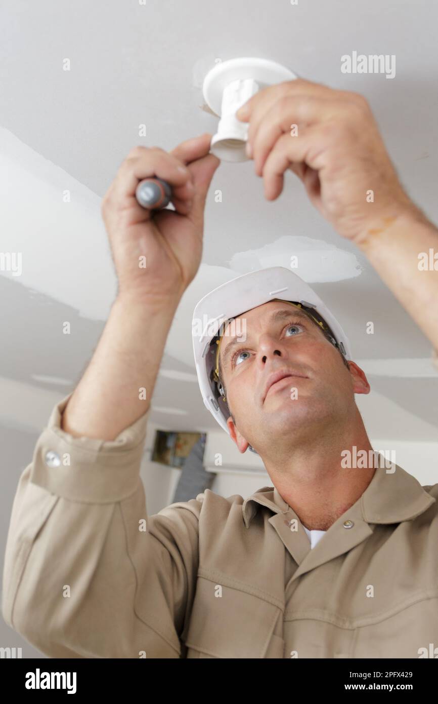 male contractor installing light fitting Stock Photo Alamy