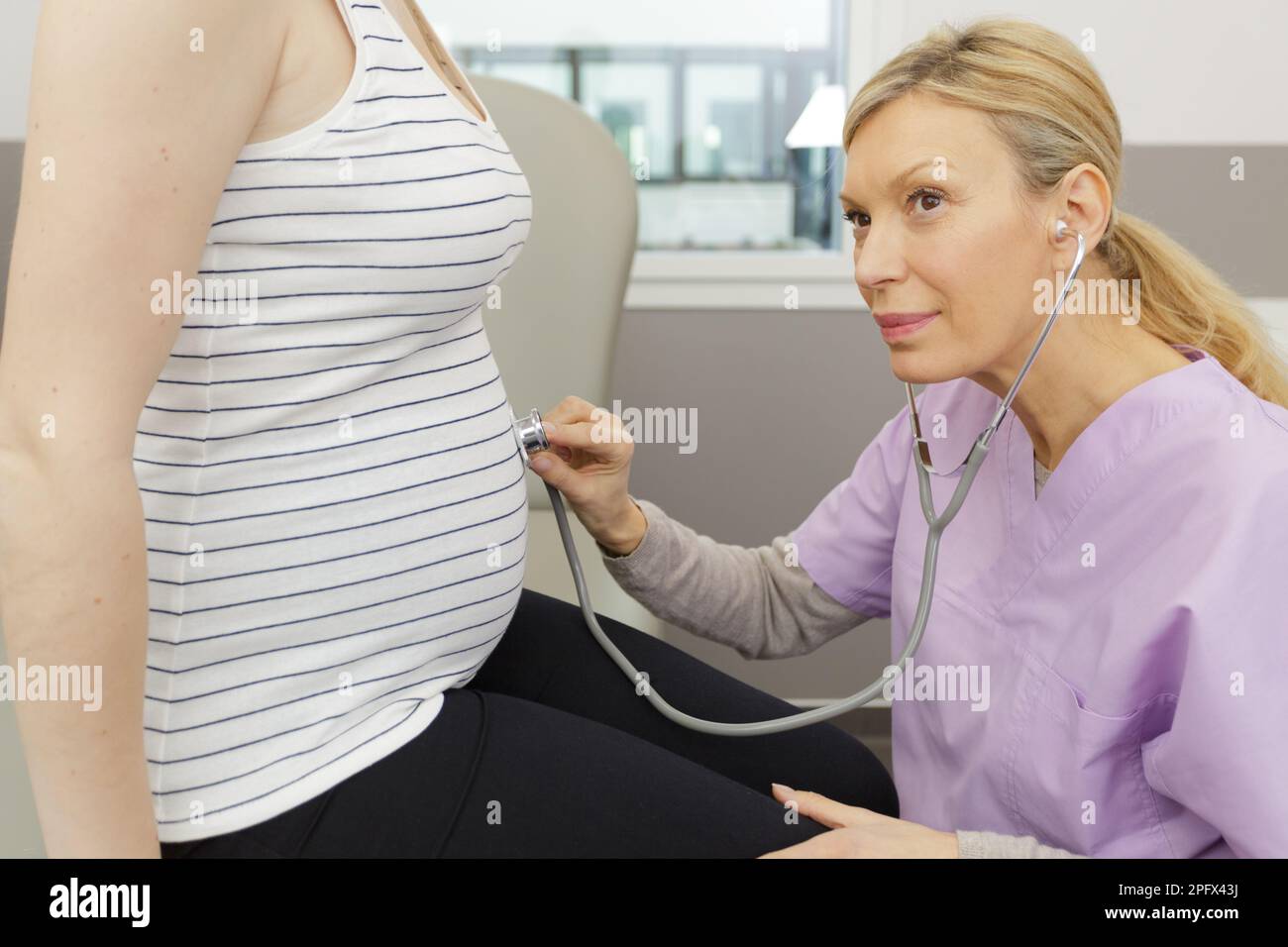 gynecologist using stethoscope to listen to unborn baby Stock Photo Alamy