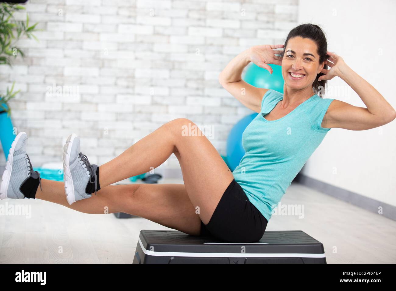 a happy woman doing abdominal at home Stock Photo