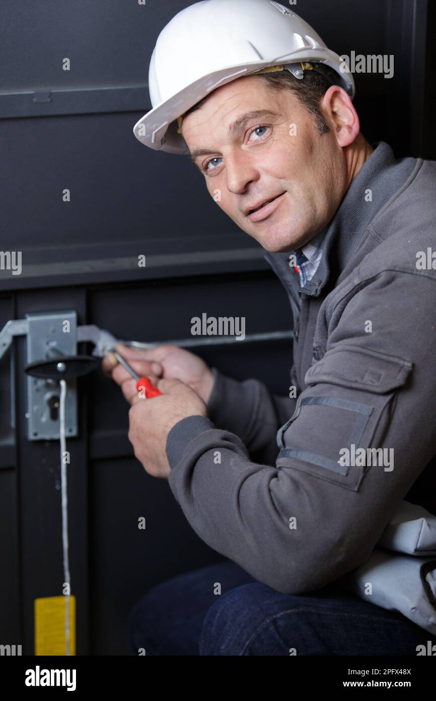 locksmith working on mechanism of garage door Stock Photo Alamy