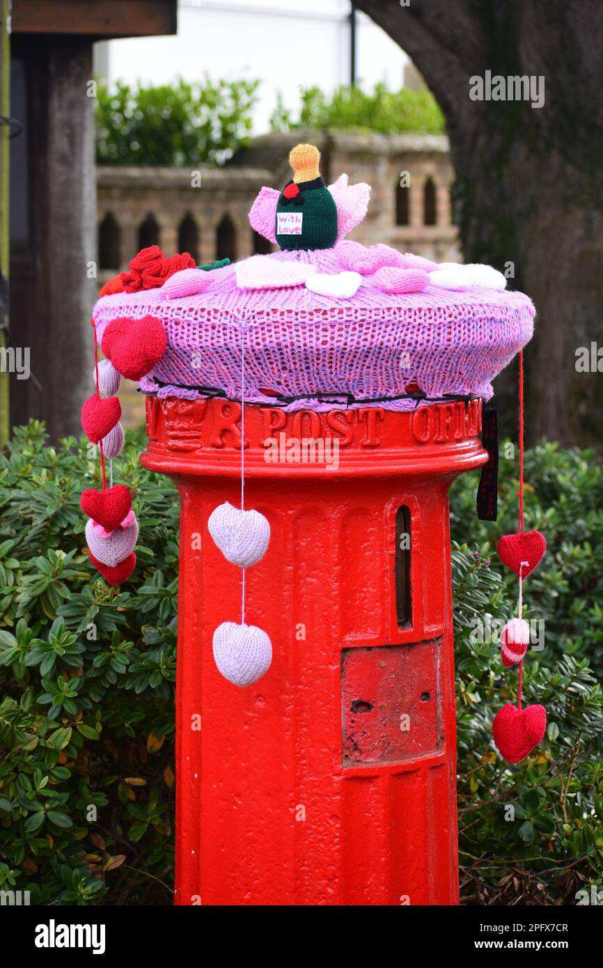 Red Victorian post box with festive knitted topper Stock Photo Alamy