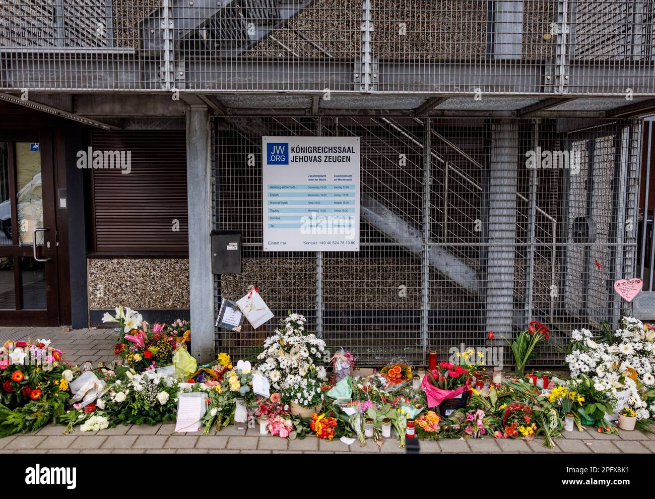 Hamburg, Germany. 19th Mar, 2023. Flowers are laid at the building where 35-year-old Philipp F. shot seven people, including an unborn child, in Hamburg-Alsterdorf. A memorial service is held for the victims of the rampage in Hamburg. Credit: Axel Heimken/dpa/Alamy Live News Stock Photo