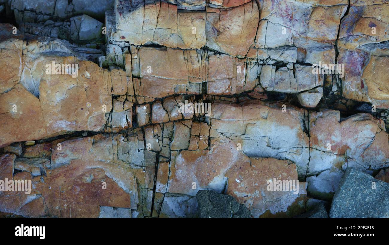 Close-up view of earthy coloured rocks with cracks and crevices, forming an abstract pattern Stock Photo