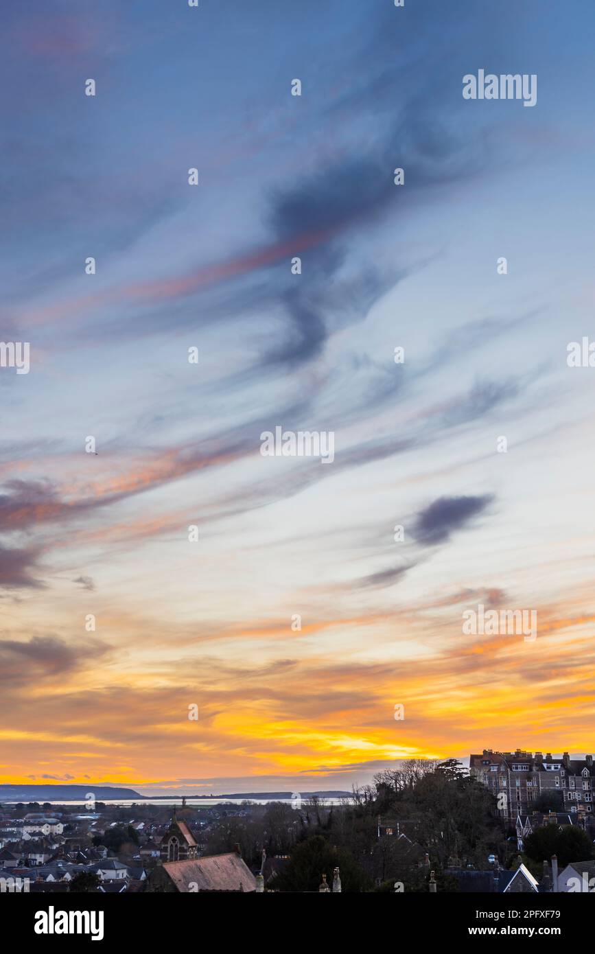 The setting sun lighting up the cloud cover Stock Photo