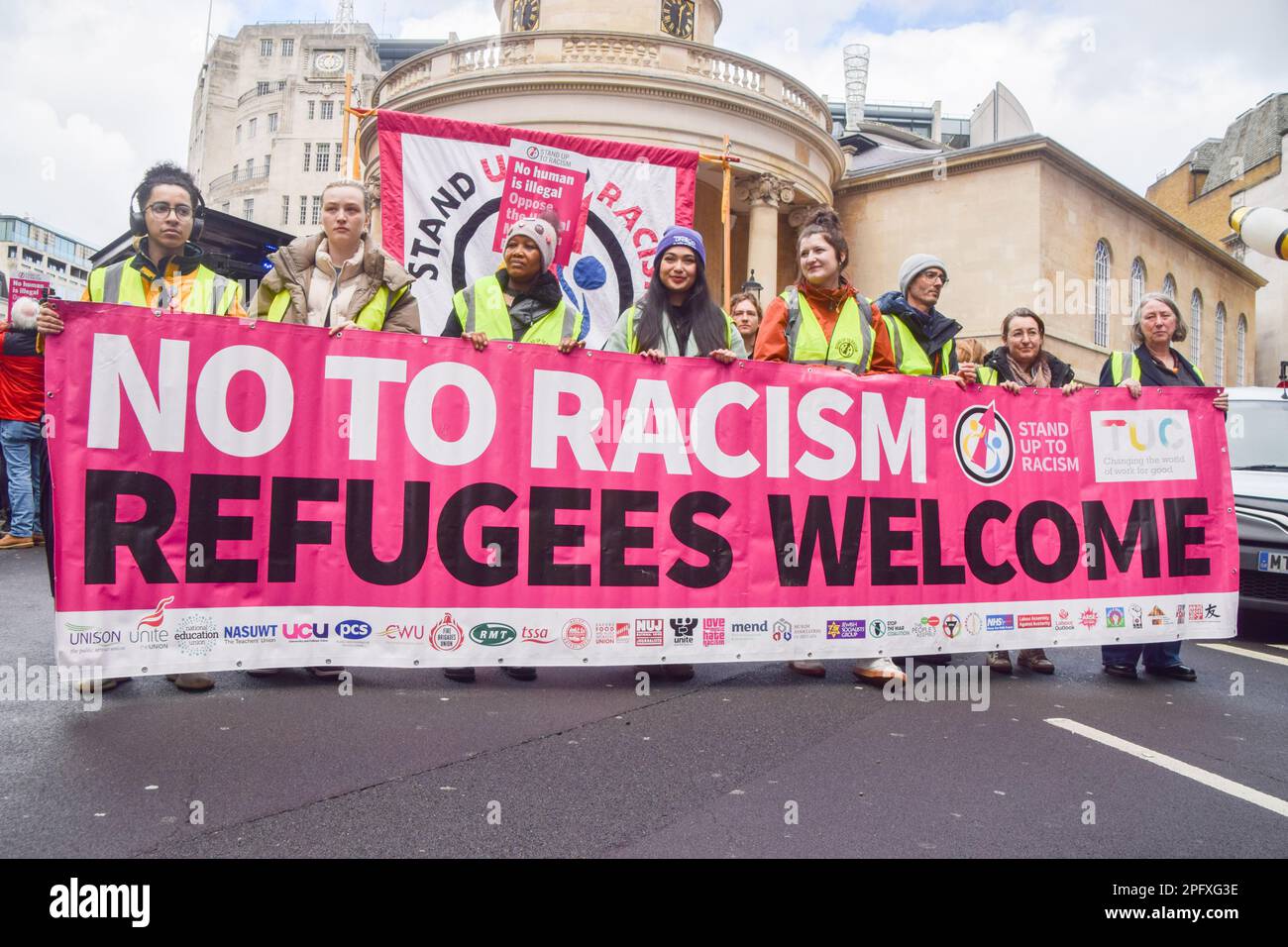 London, UK. 18th March 2023. Protesters outside BBC headquarters. Thousands of people marched through Central London in support of refugees, and in protest against racism and the UK Government's Illegal Migration Bill. Stock Photo