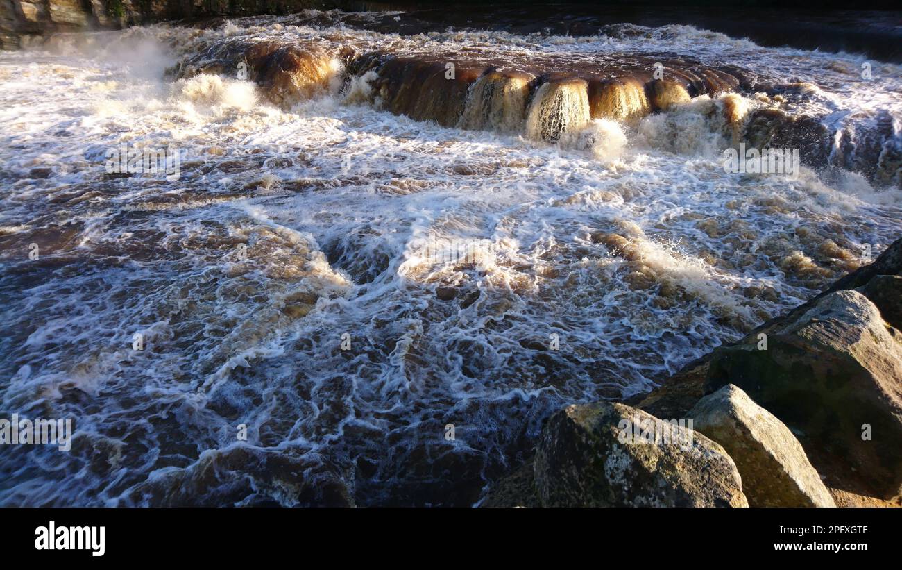 The waves hitting over rocks in a river Stock Photo - Alamy