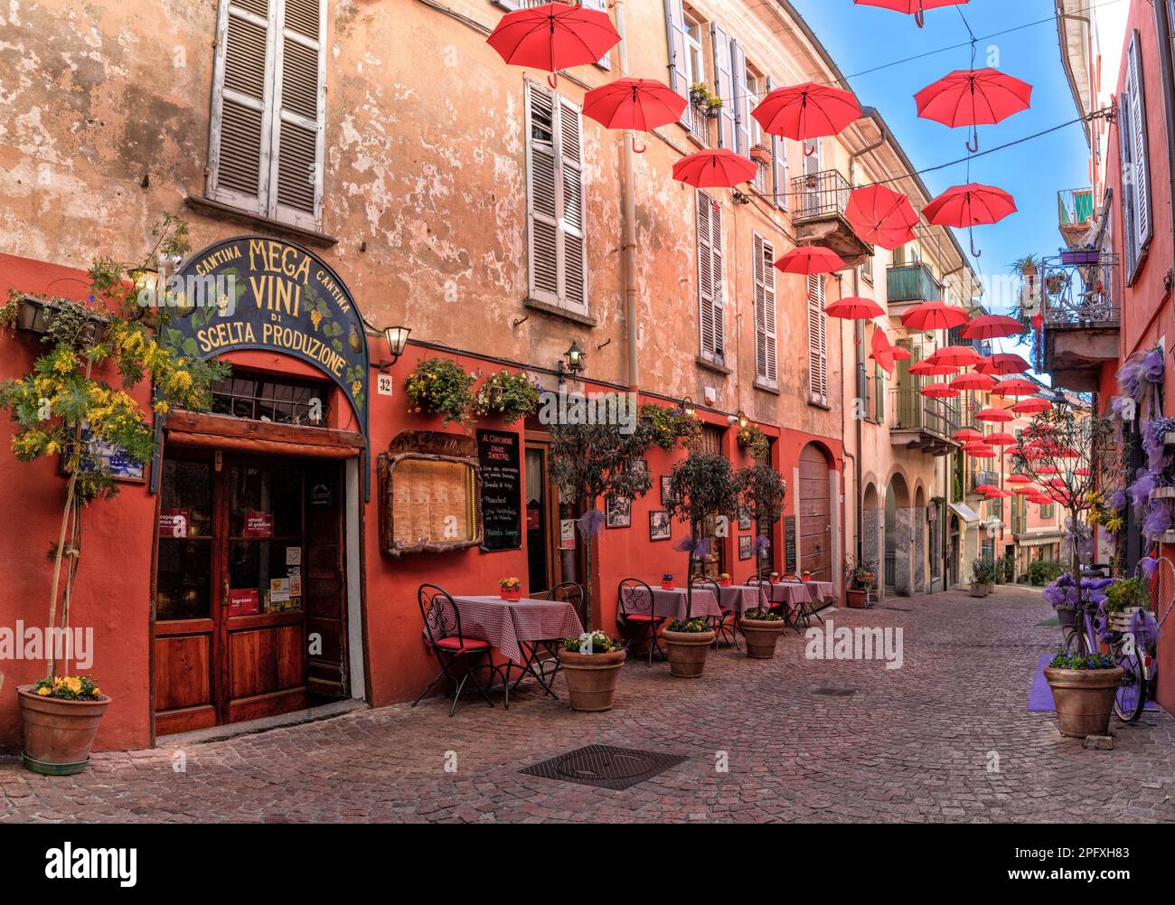 Luino, Italy - 16 March, 2023: cobblestone street with small shops and colorful decorations in the old city center of Luino Stock Photo