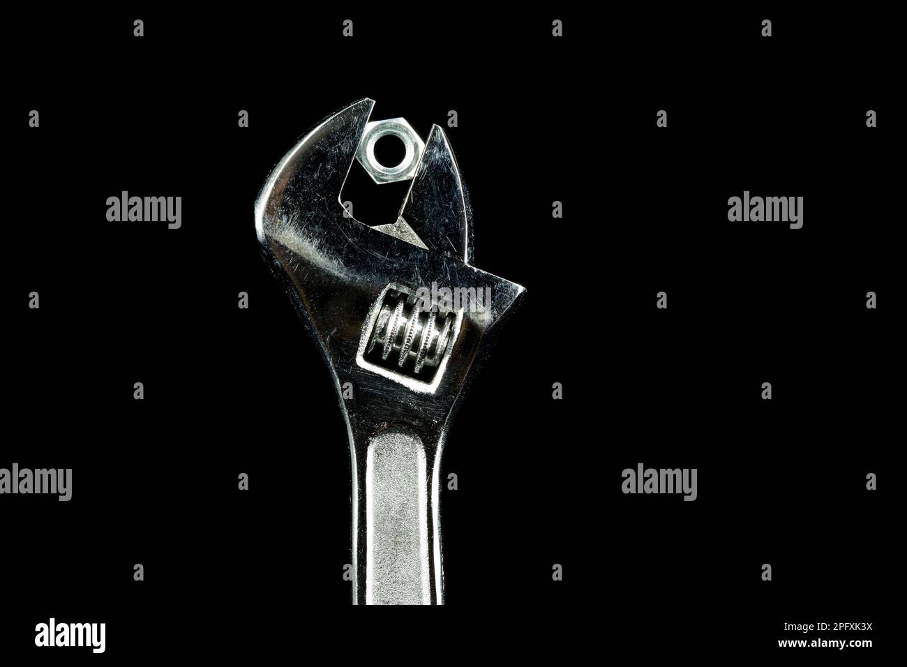 Ols adjustable wrench with nut isolated on black Stock Photo