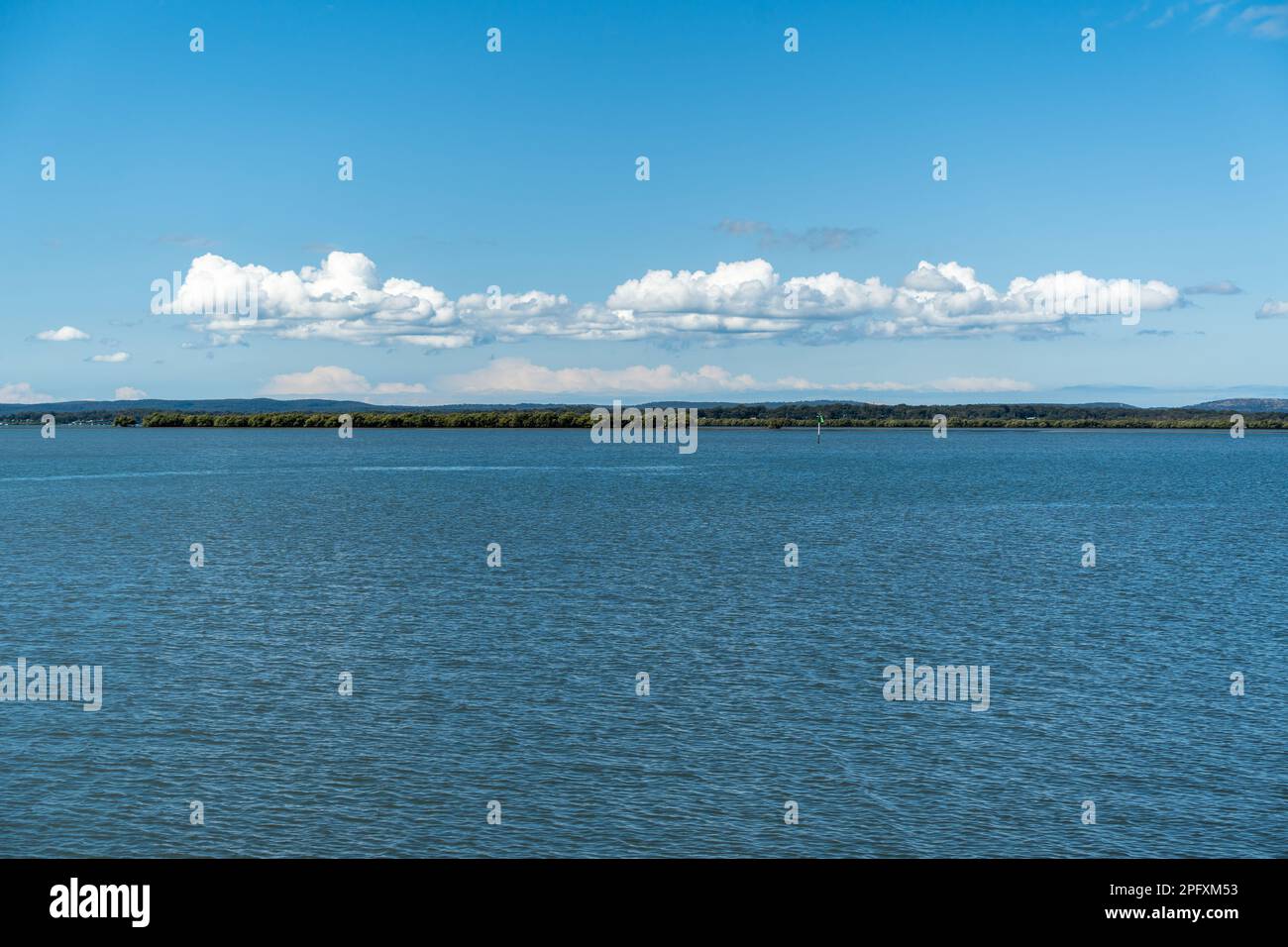 View from Redland Bay across and expanse of water with southern Moreton Bay Islands in the distance and clouds low over the horizon Stock Photo