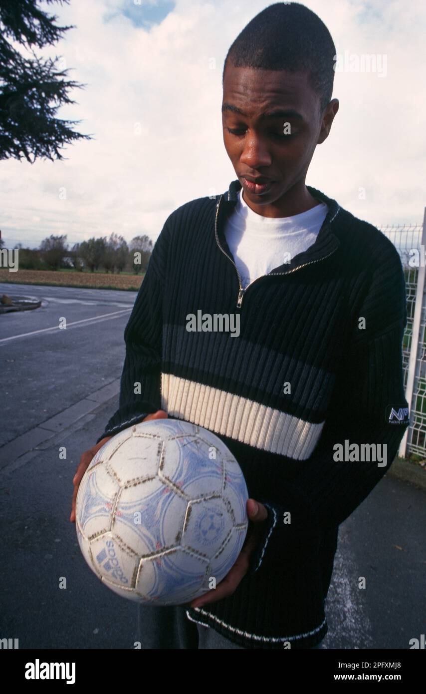 Marcq-en-baroeul France Black Teenage Boy Carrying Football in the Street Stock Photo