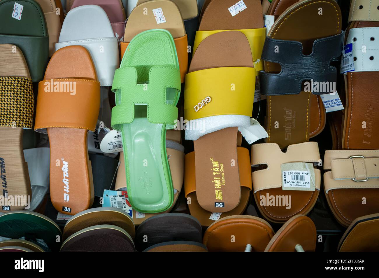 Women's sandals, including fake Gucci branded shoes, for sale in a shoe shop in Dalat, Vietnam. Stock Photo
