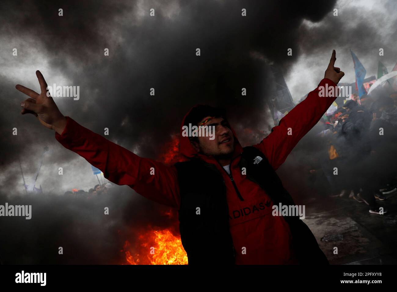 A man flashes V-signs in front of a bonfire during a rally to celebrate Nowruz, which marks the arrival of spring, in Istanbul, Turkey March 19, 2023. REUTERS/Murad Sezer Stock Photo