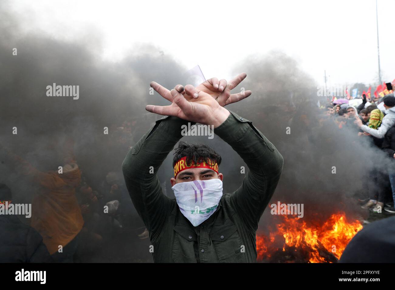 A man flashes V-signs in front of a bonfire during a rally to celebrate Nowruz, which marks the arrival of spring, in Istanbul, Turkey March 19, 2023. REUTERS/Murad Sezer Stock Photo