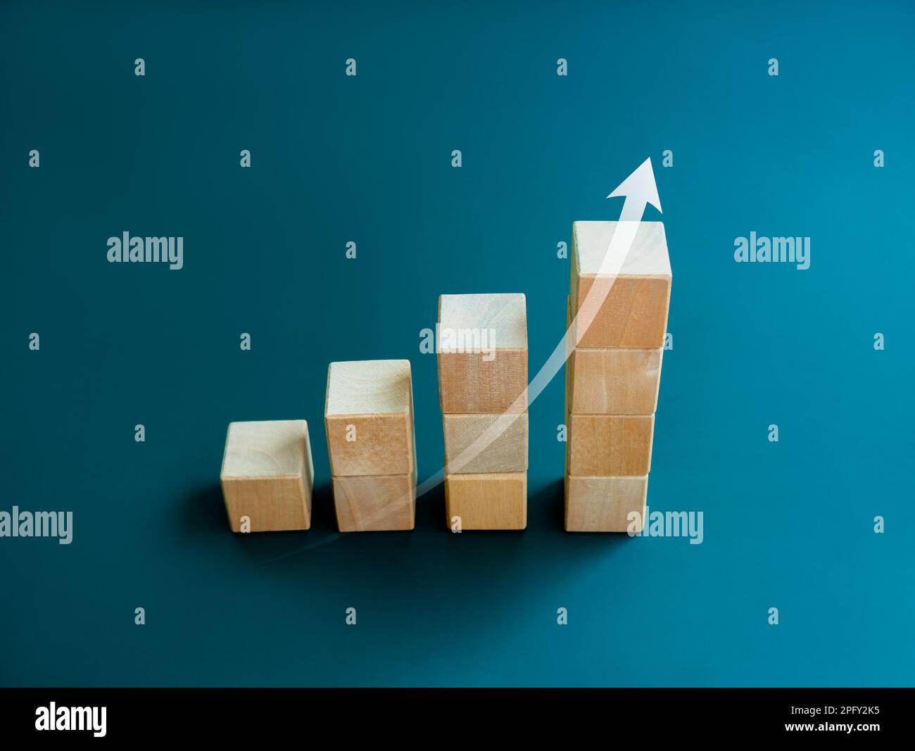 White rising up arrow draw on wooden cube blocks bar graph chart steps on blue background, minimal style. Purchase trend increase, income, inflation, Stock Photo