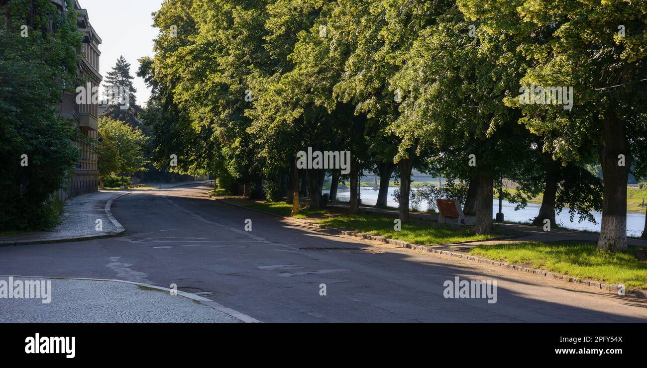 river in the town at sunrise. longest linden alley in europe. popular travel destination Stock Photo