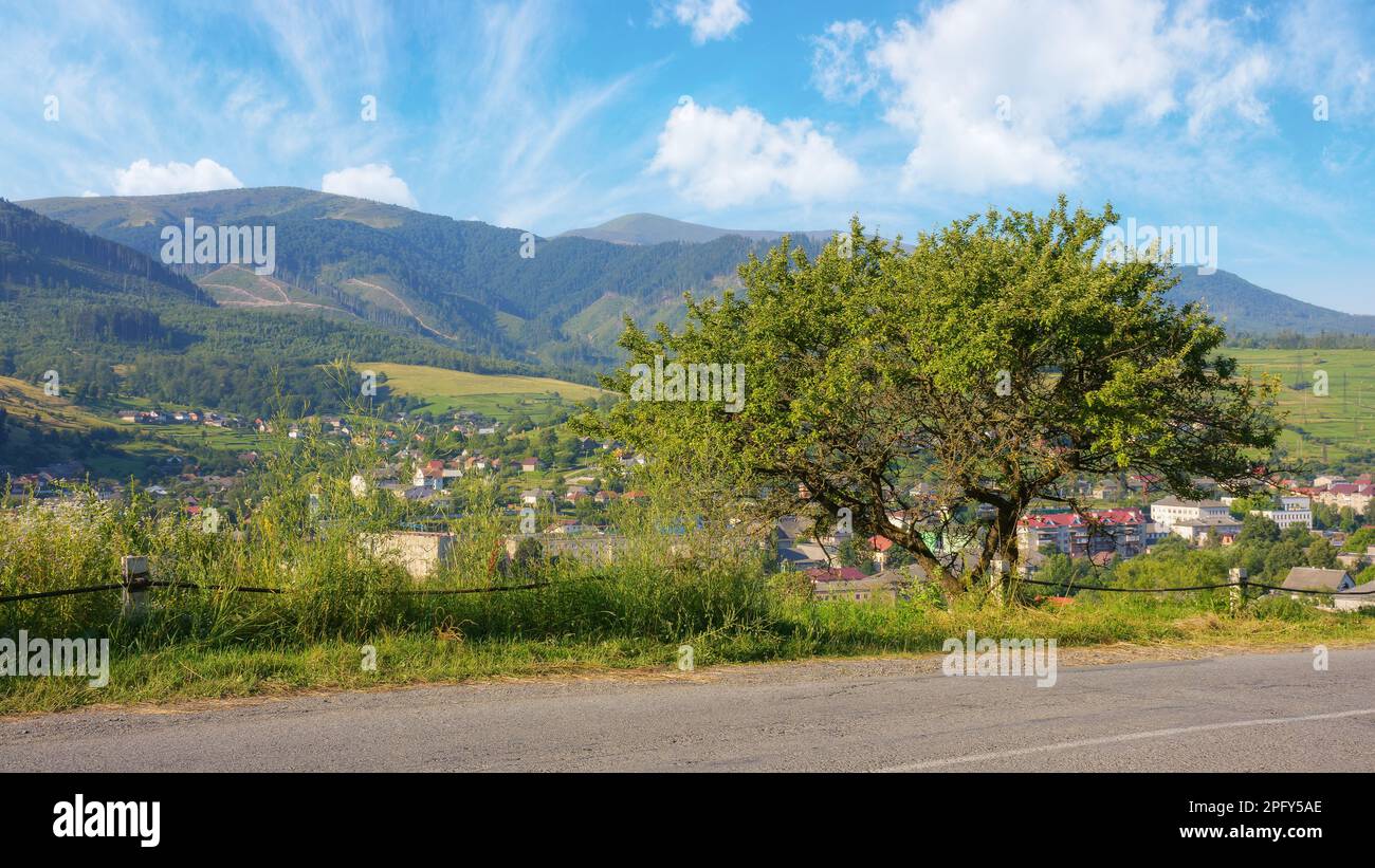 peaceful scenery, surrounded by the green hills and majestic mountains. road runs through the rural landscape, providing a picturesque view of the pea Stock Photo