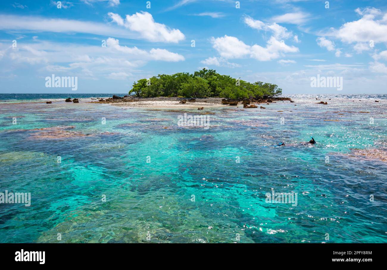 Tropical islet surrounded by coral reef lagoon. Stock Photo
