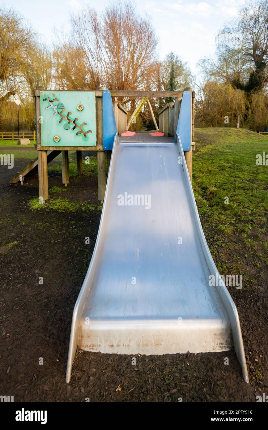 Stainless steel silver slide coming off wooden play structure in