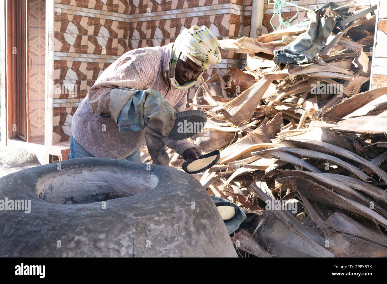 Nefta, Tunisia. 01st Mar, 2023. A man prepares Berber bread tabouna in an oven. Credit: Sebastian Kahnert/dpa/Alamy Live News Stock Photo