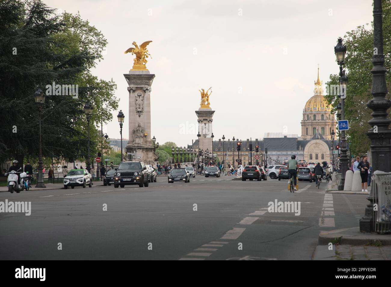 View of the street and the Pont Alexandre bridge with the golden dome of the Invalides Cathedral in Paris. Stock Photo