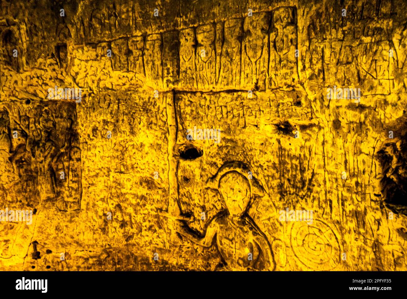 Royston Cave in Herfordshire U.K. still puzzles historians today. The cave is decorated with a large number of low-relief wall sculptures. They are mainly Christian motifs in the medieval style. The figure with the drawn swort may represent St Michael or possibly St George, who was later patron saint of England. The figure's swort points to what appears to be Jasus and the twelve disciples with Judas the small figure at the back towards the right-hand end of the row. Royston Cave in Katherine's Yard, Melbourn Street, Royston, England Stock Photo