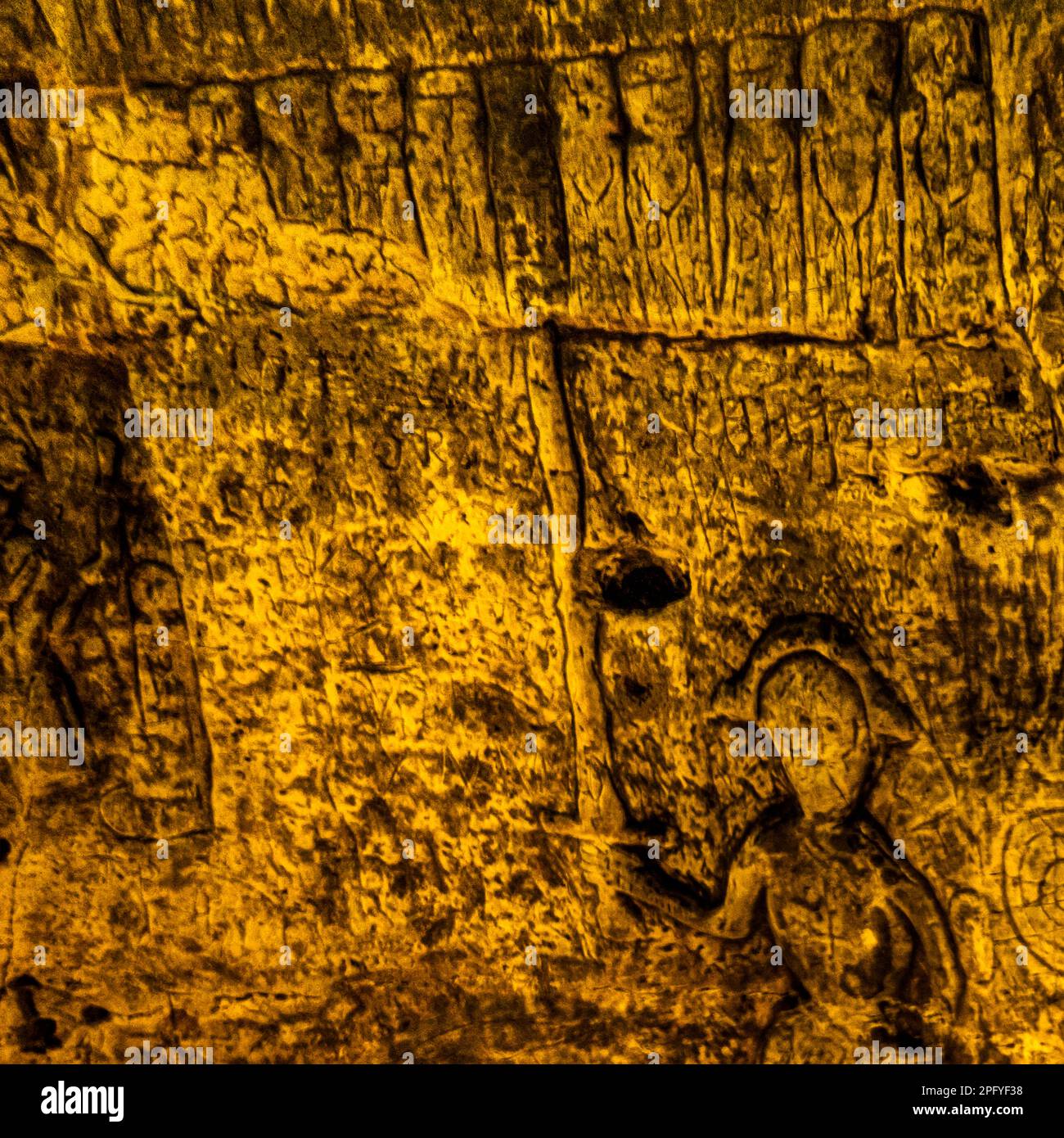 Royston Cave in Herfordshire U.K. still puzzles historians today. The cave is decorated with a large number of low-relief wall sculptures. They are mainly Christian motifs in the medieval style. The figure with the drawn swort may represent St Michael or possibly St George, who was later patron saint of England. The figure's swort points to what appears to be Jasus and the twelve disciples with Judas the small figure at the back towards the right-hand end of the row. Royston Cave in Katherine's Yard, Melbourn Street, Royston, England Stock Photo