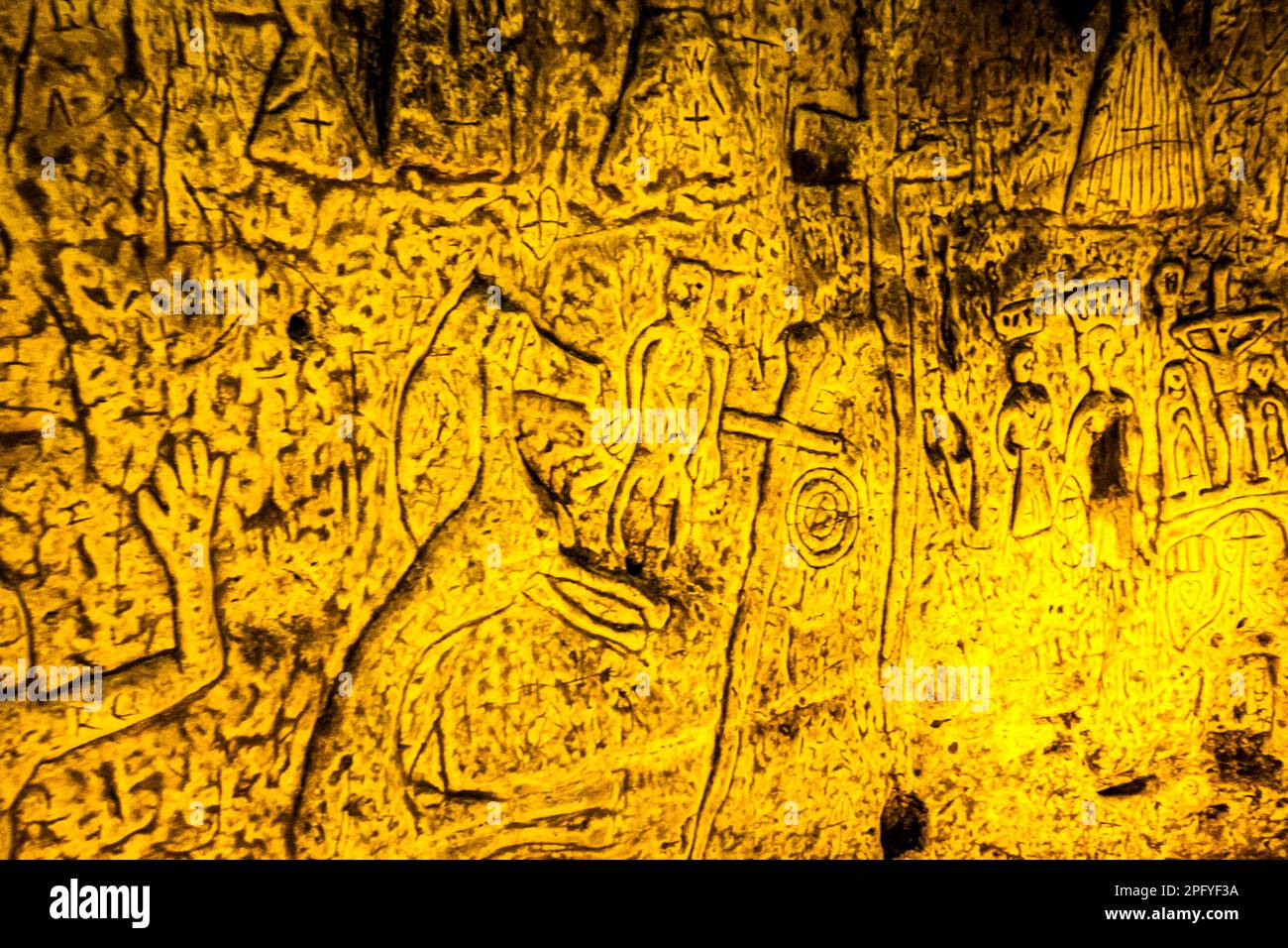 Royston Cave in Herfordshire U.K. still puzzles historians today. The cave is decorated with a large number of low-relief wall sculptures. They are mainly Christian motifs in the medieval style. At the top left is depicted a crucifixion scene. Royston Cave in Katherine's Yard, Melbourn Street, Royston, England Stock Photo