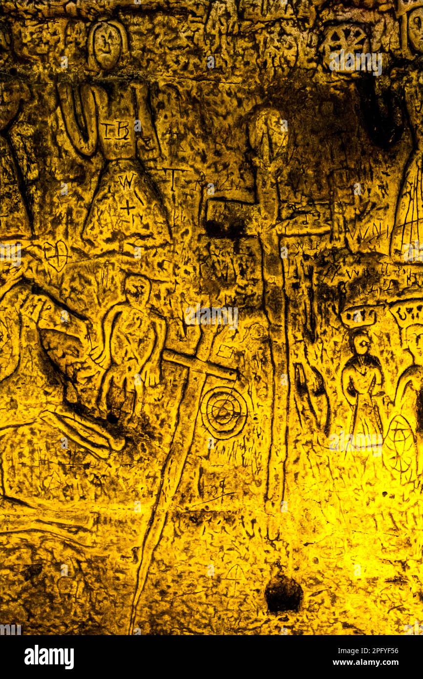 Royston Cave in Herfordshire U.K. still puzzles historians today. The cave is decorated with a large number of low-relief wall sculptures. They are mainly Christian motifs in the medieval style. Royston Cave in Katherine's Yard, Melbourn Street, Royston, England Stock Photo