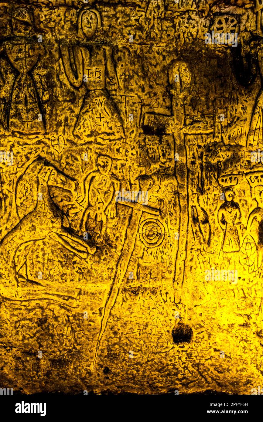 Royston Cave in Herfordshire U.K. still puzzles historians today. The cave is decorated with a large number of low-relief wall sculptures. They are mainly Christian motifs in the medieval style. Royston Cave in Katherine's Yard, Melbourn Street, Royston, England Stock Photo