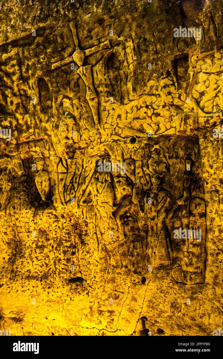 Royston Cave in Herfordshire U.K. still puzzles historians today. The cave is decorated with a large number of low-relief wall sculptures. They are mainly Christian motifs in the medieval style. At the top left is depicted a crucifixion scene. Royston Cave in Katherine's Yard, Melbourn Street, Royston, England Stock Photo