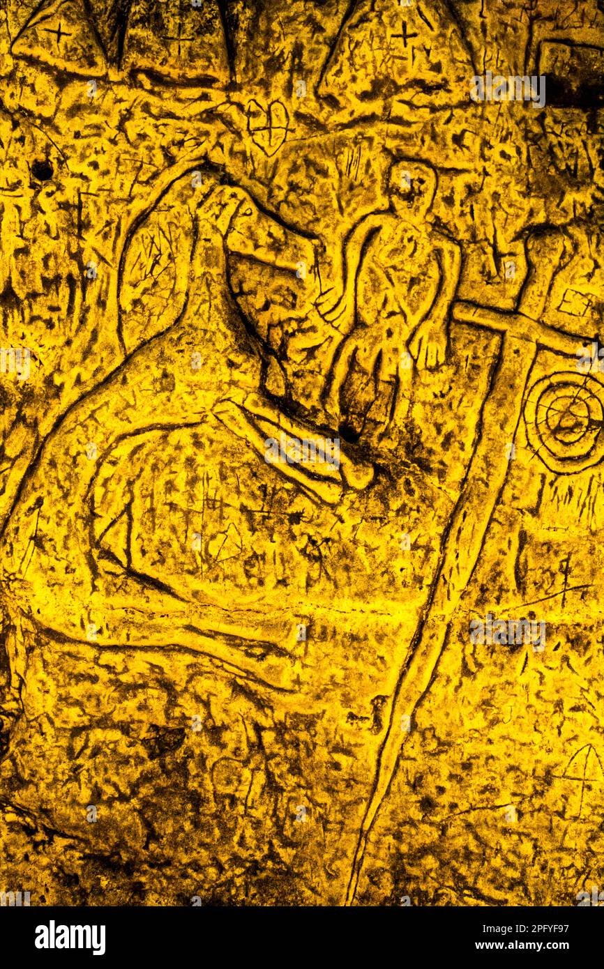 Royston Cave in Herfordshire U.K. still puzzles historians today. The cave is decorated with a large number of low-relief wall sculptures. They are mainly Christian motifs in the medieval style. At the top left is depicted a crucifixion scene. Royston Cave in Katherine's Yard, Melbourn Street, Royston, England Stock Photo