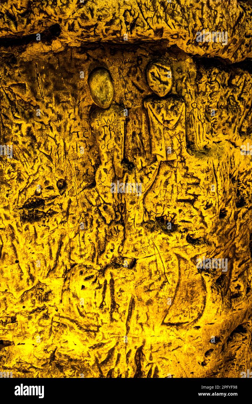 Royston Cave in Herfordshire U.K. still puzzles historians today. The cave is decorated with a large number of low-relief wall sculptures. They are mainly Christian motifs in the medieval style. At the top left is depicted a crucifixion scene. Royston Cave in Katherine's Yard, Melbourn Street, Royston, England Stock Photo