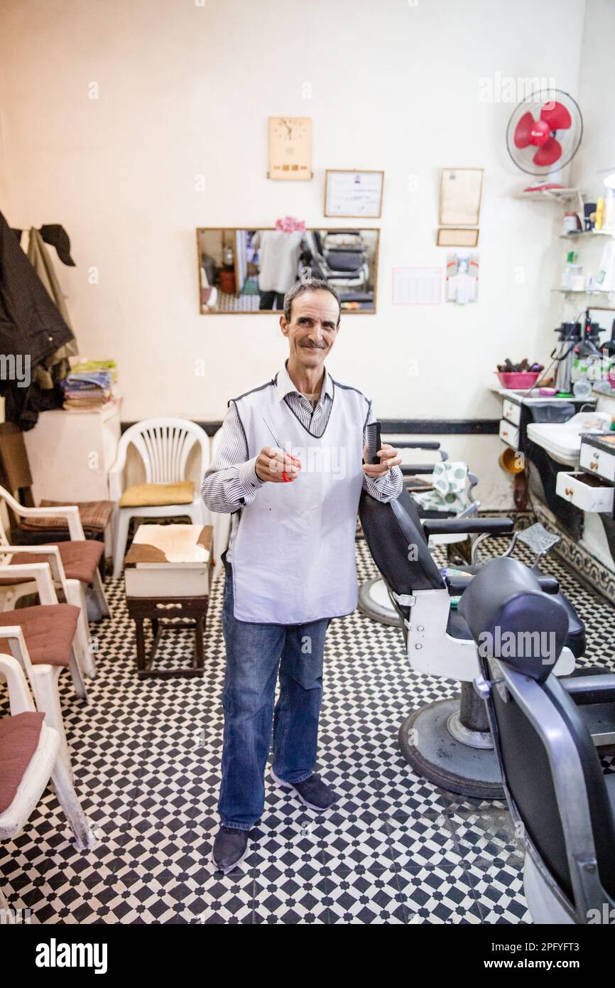 A barber standing in his barbershop in Marrakech Morocco Stock Photo