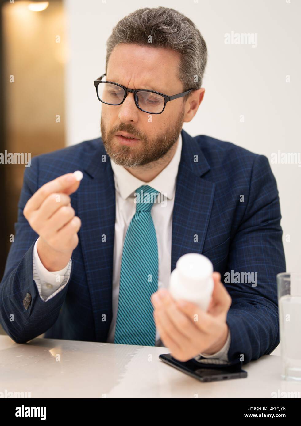 Man taking a medicine pill from headache migraine. Overworked man