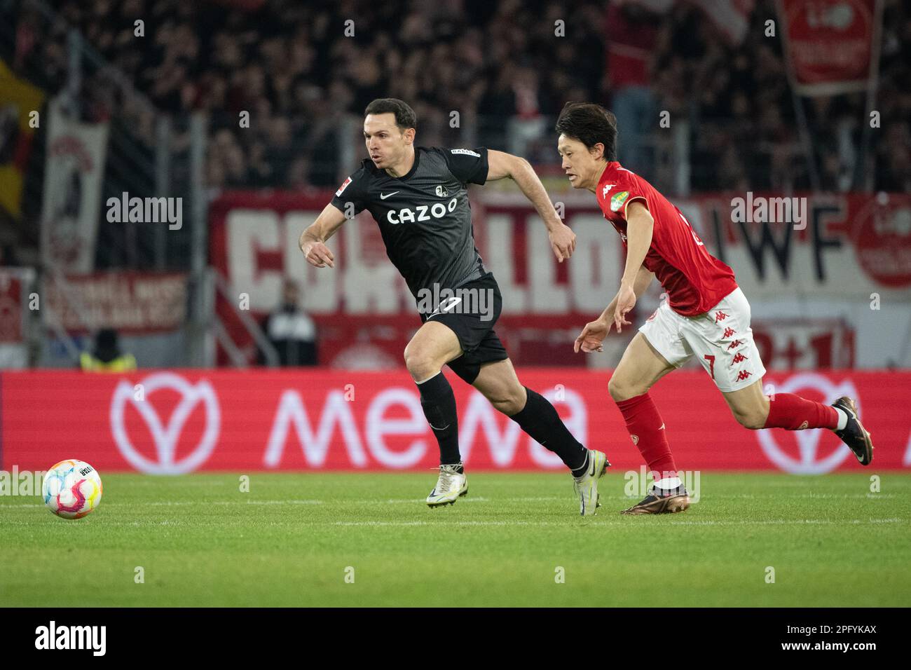 Mainz, Germany. 19th Mar, 2023. Soccer: Bundesliga, FSV Mainz 05 - SC Freiburg, Matchday 25, Mewa Arena. Freiburg's Nicolas Höfler (l) and Mainz's Jae-sung Lee fight for the ball. Credit: Sebastian Gollnow/dpa - IMPORTANT NOTE: In accordance with the requirements of the DFL Deutsche Fußball Liga and the DFB Deutscher Fußball-Bund, it is prohibited to use or have used photographs taken in the stadium and/or of the match in the form of sequence pictures and/or video-like photo series./dpa/Alamy Live News Stock Photo