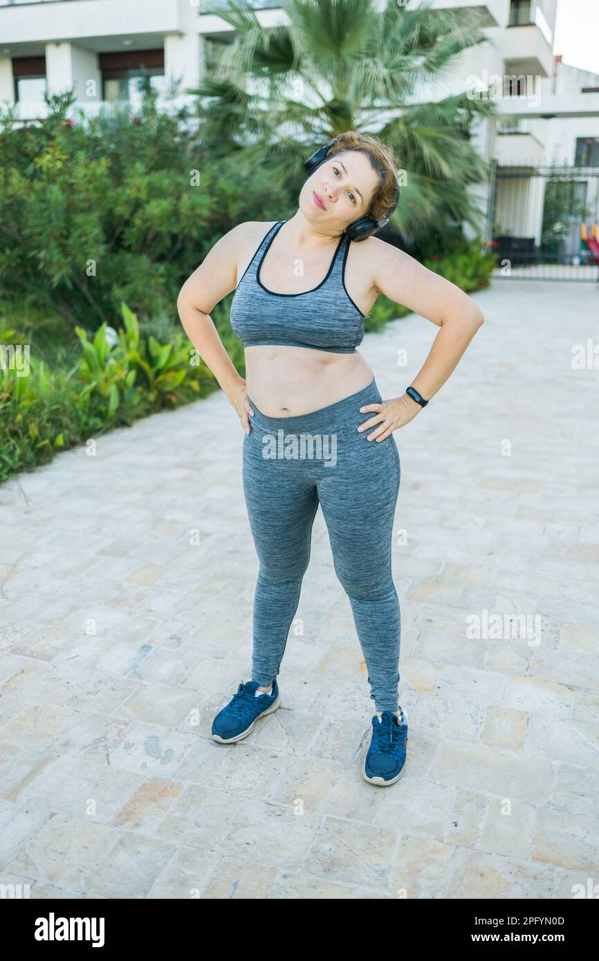 Young plus size woman in sporty top and leggings standing in plank