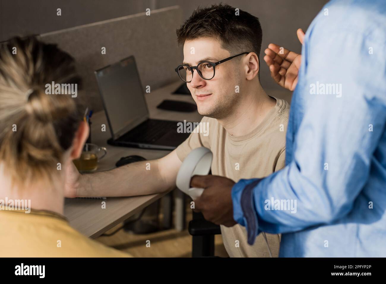 IT Development Team Working on VR Project. Man wearing VR headset, playing and touching something in the virtual world. Diverse men programmers using Stock Photo