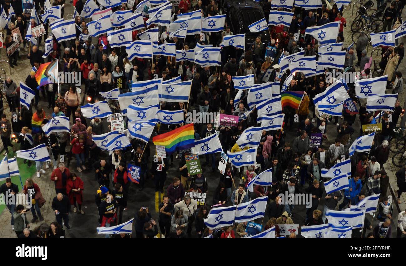 TEL AVIV, ISRAEL - MARCH 18: Anti-government protesters hold Israeli flags and traditional gay pride rainbow flag during a mass demonstration for the 11th consecutive week against Israel's hard-right government judicial system plan that aims to weaken the country's Supreme Court on March 18, 2023 in Tel Aviv, Israel. Credit: Eddie Gerald/Alamy Live News Stock Photo