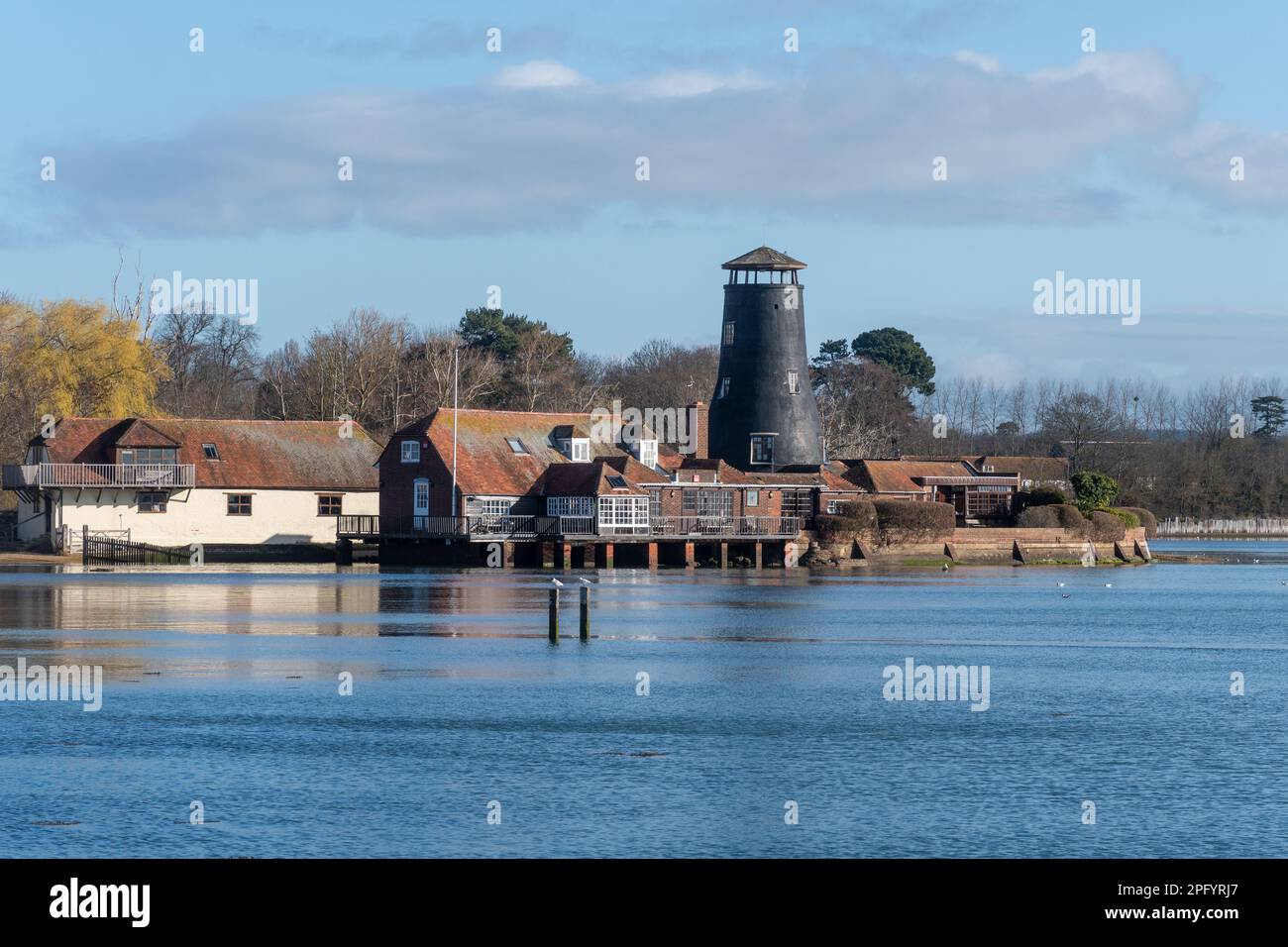 Langstone Harbour, view of the village, old mill and Royal Oak Pub on the seafront, Langstone, Hampshire, England, UK, on a sunny day in March Stock Photo