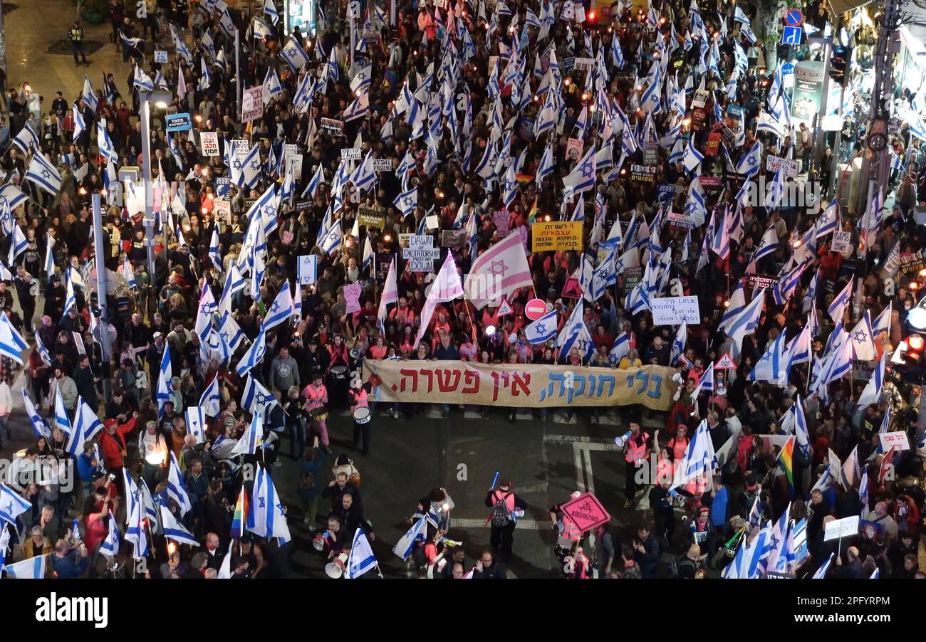 TEL AVIV, ISRAEL - MARCH 18: Anti-government protesters hold Israeli flags and a large banner which reads 'Without a constitution there is no compromise' during a mass demonstration for the 11th consecutive week against Israel's hard-right government judicial system plan that aims to weaken the country's Supreme Court on March 18, 2023 in Tel Aviv, Israel. Credit: Eddie Gerald/Alamy Live News Stock Photo