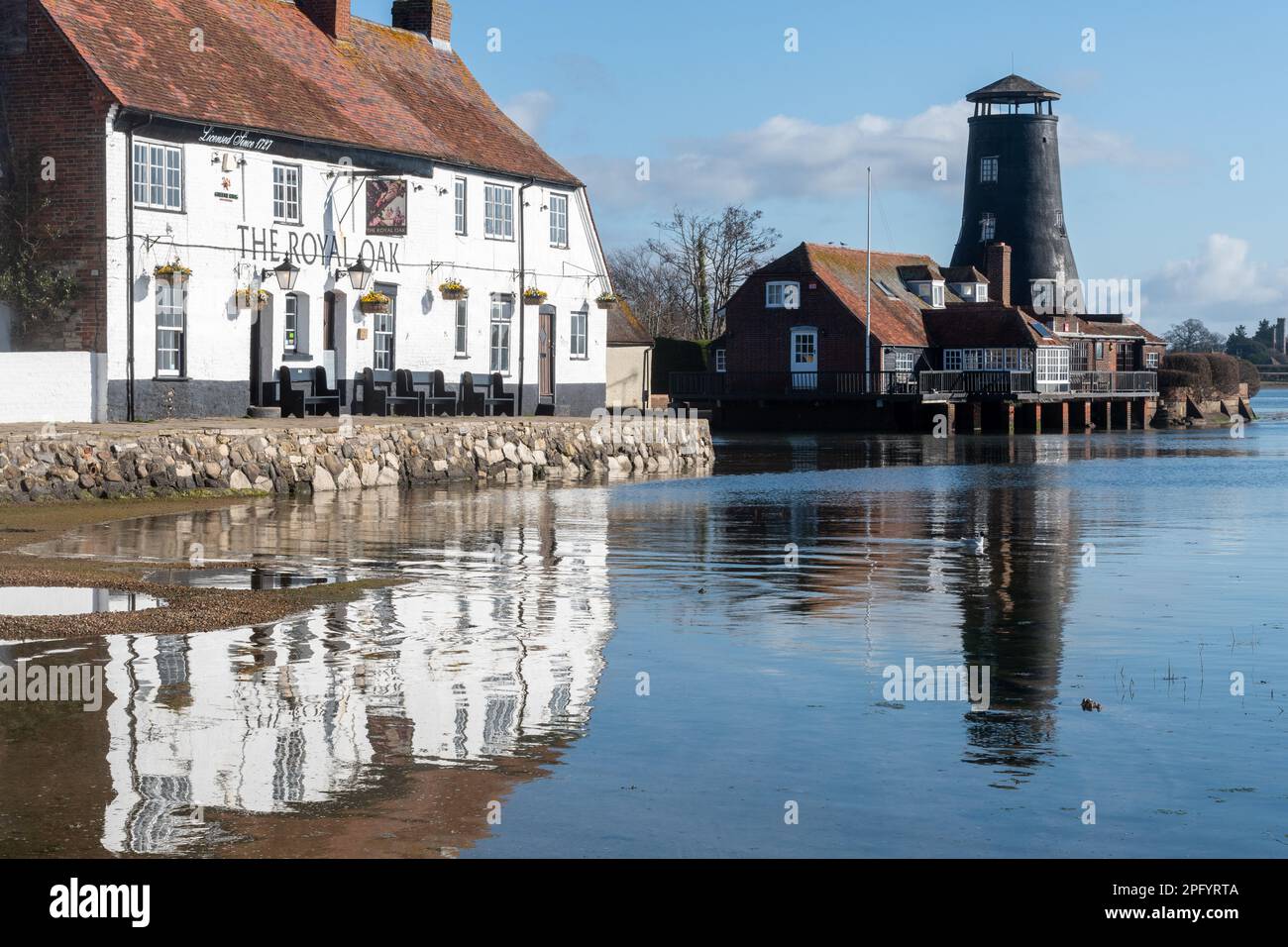 Langstone Harbour, view of the village, old mill and Royal Oak Pub on the seafront, Langstone, Hampshire, England, UK, on a sunny day Stock Photo