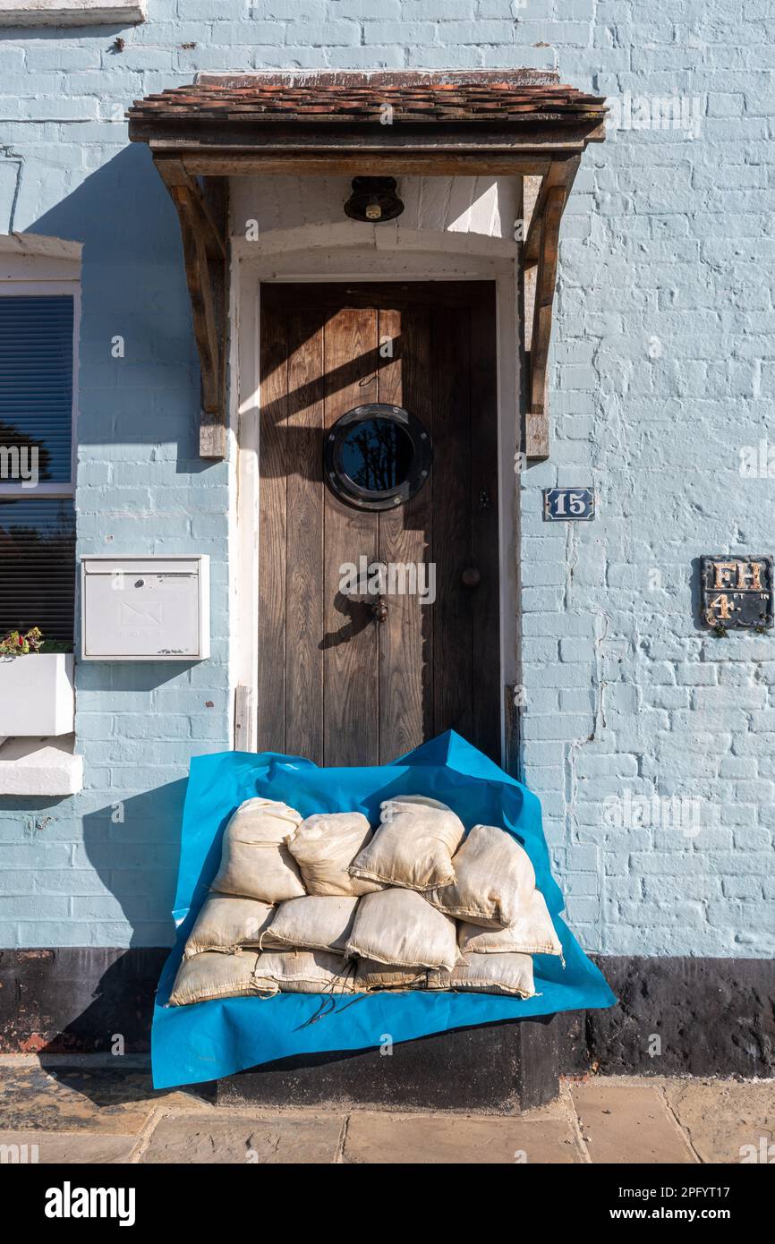 Sand bags piled at front door of a house near the sea, Langstone, Hampshire, UK. Highest flood water level marked on the wall. Stock Photo
