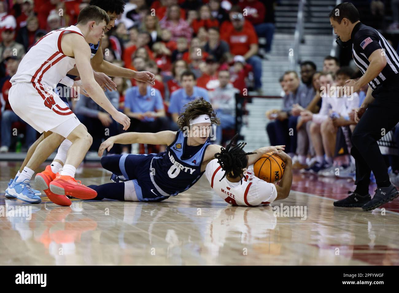 Madison, WI, USA. 19th Mar, 2023. Wisconsin Badgers guard Kamari McGee (4)  causes a jump ball against Liberty Flames guard Colin Porter (0) during the  NCAA basketball NIT Second Round game between